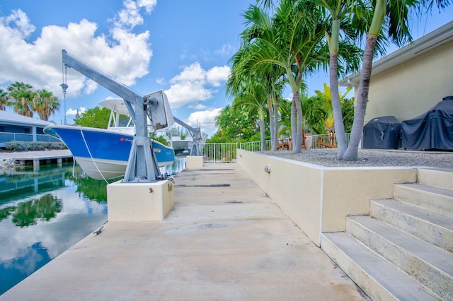 view of patio / terrace with a boat dock and a water view