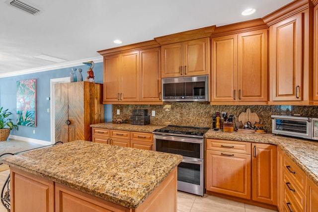 kitchen featuring stainless steel appliances, ornamental molding, light stone countertops, and backsplash