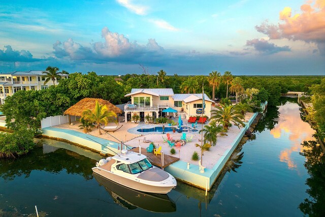 exterior space with a balcony, a water view, and a patio area