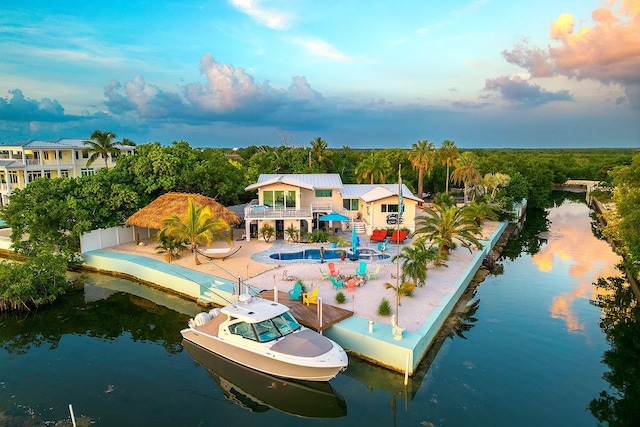 exterior space with a balcony, a water view, and a patio area