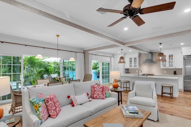 living room with sink, crown molding, beamed ceiling, ceiling fan, and light hardwood / wood-style floors