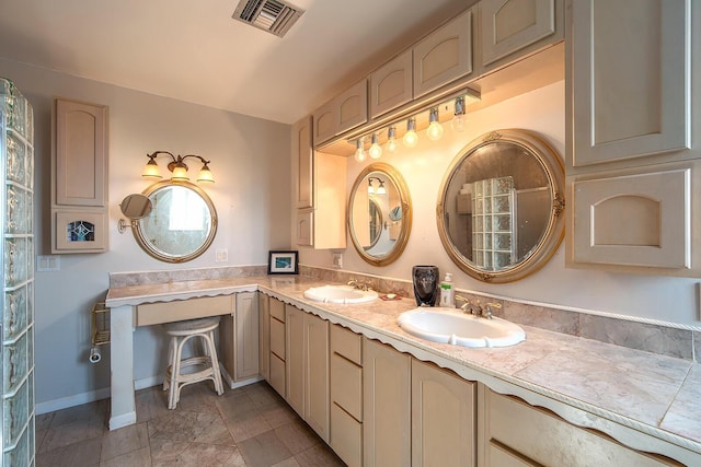 full bath with double vanity, baseboards, visible vents, and a sink