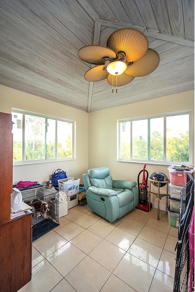 interior space with light tile patterned floors, ceiling fan, vaulted ceiling, and wood ceiling