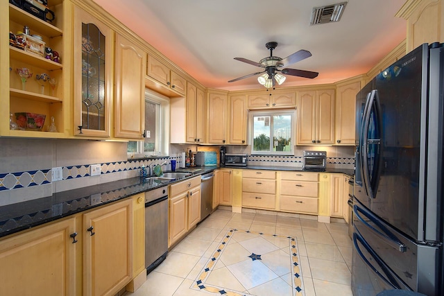 kitchen with light tile patterned floors, light brown cabinets, and freestanding refrigerator