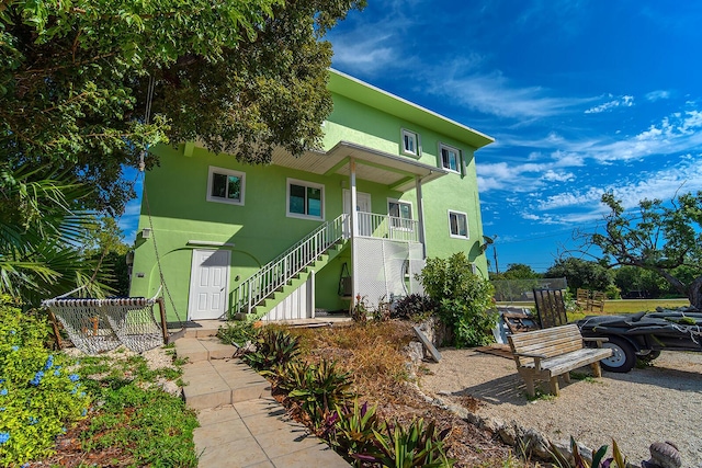 coastal home with stucco siding and stairs