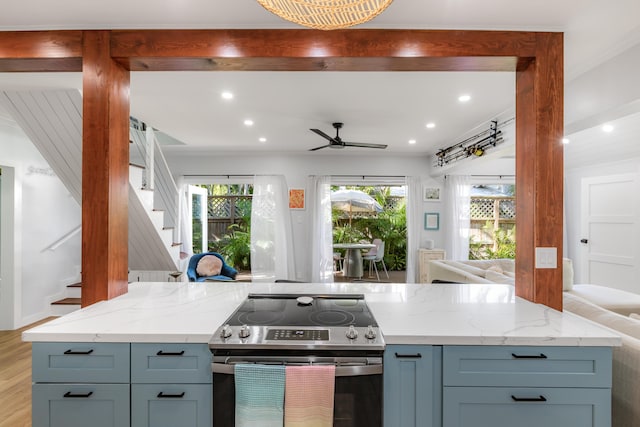 kitchen with stainless steel electric range oven, light wood-type flooring, ornamental molding, ceiling fan, and light stone countertops