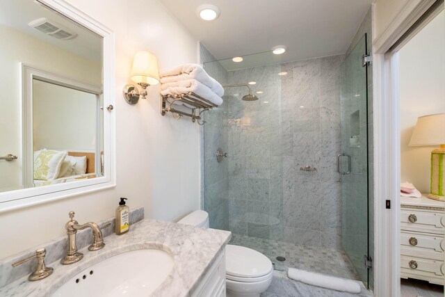 bathroom with a shower with door, vanity, and toilet