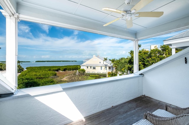 wooden terrace with a water view and ceiling fan