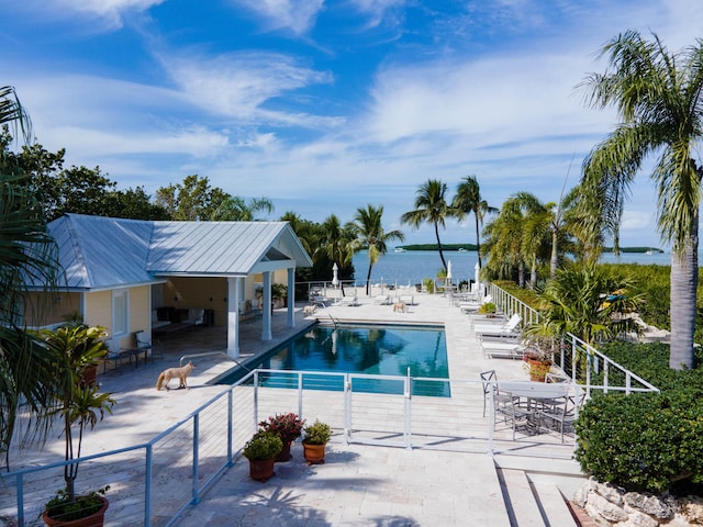 view of swimming pool with a water view and a patio