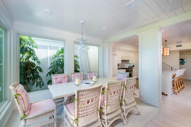 dining area with light hardwood / wood-style flooring, wooden ceiling, and a chandelier