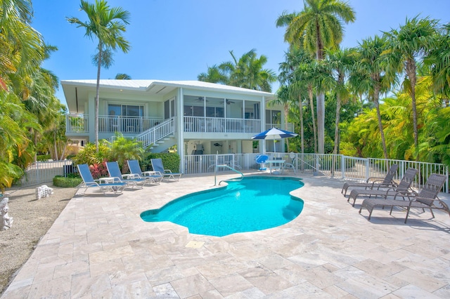 view of swimming pool featuring a patio and a sunroom