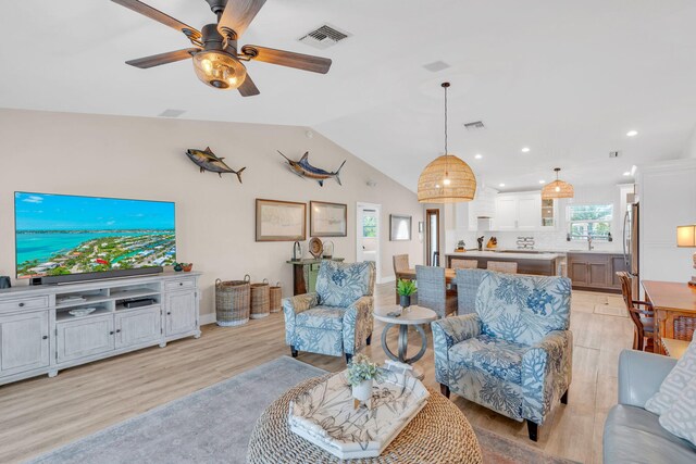 living room with vaulted ceiling, light hardwood / wood-style floors, and ceiling fan