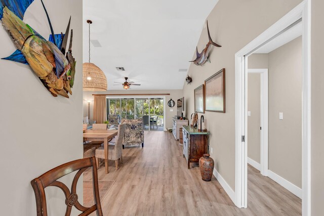 hall featuring lofted ceiling and light hardwood / wood-style floors