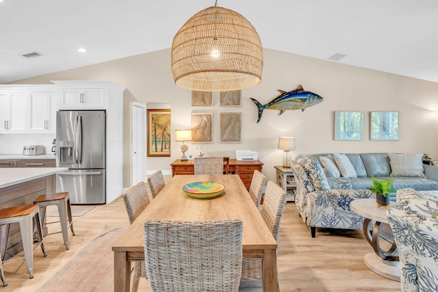 dining room with lofted ceiling and light hardwood / wood-style floors