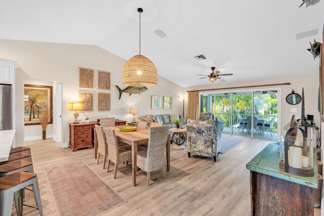 dining room with ceiling fan, lofted ceiling, and light hardwood / wood-style floors