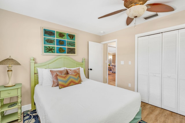 bedroom with ceiling fan, wood-type flooring, and a closet