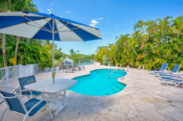 view of pool with a water view and a patio area