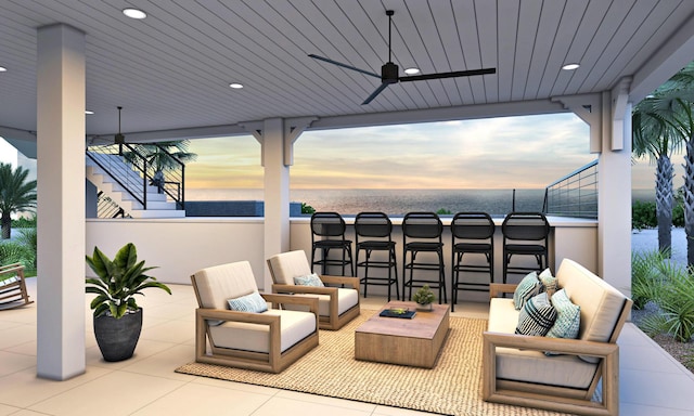 patio terrace at dusk with ceiling fan, exterior bar, and an outdoor hangout area