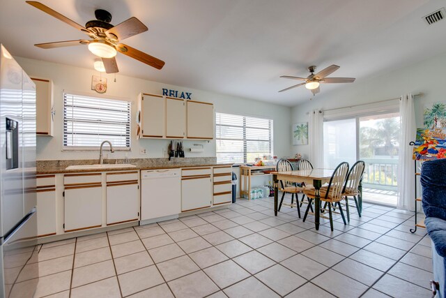 kitchen featuring refrigerator with ice dispenser, dishwasher, sink, and light tile patterned floors