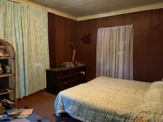 bedroom with wood walls and carpet