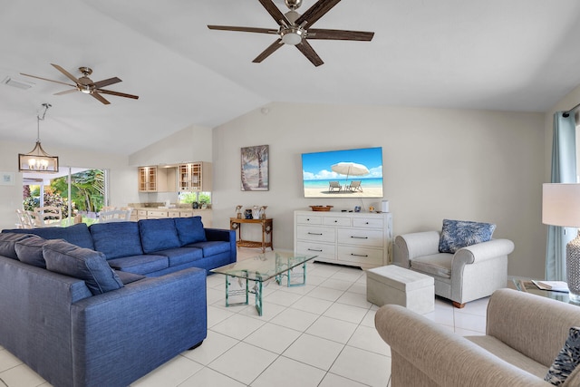 tiled living room featuring lofted ceiling and ceiling fan with notable chandelier