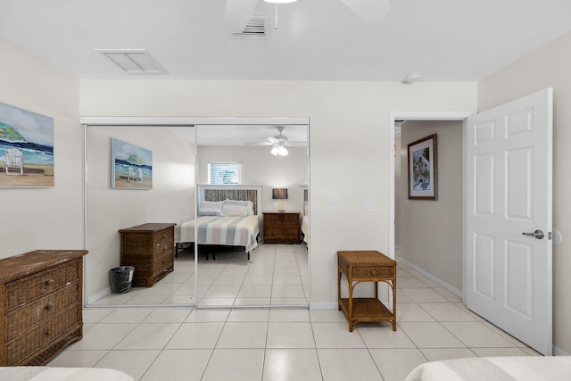 bedroom featuring light tile patterned floors, a closet, and ceiling fan