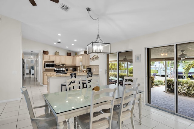 tiled dining room with lofted ceiling and ceiling fan with notable chandelier