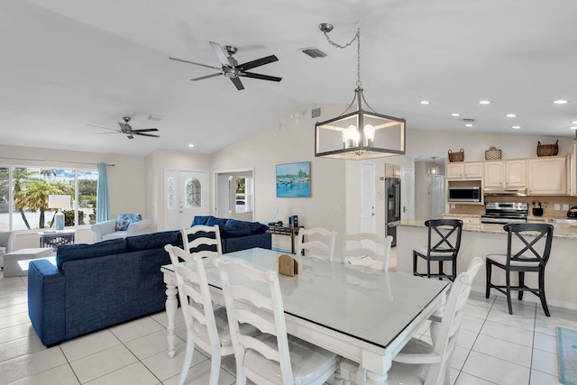 tiled dining room with lofted ceiling and ceiling fan with notable chandelier