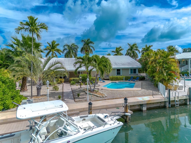 exterior space featuring a patio, a boat dock, and a water view