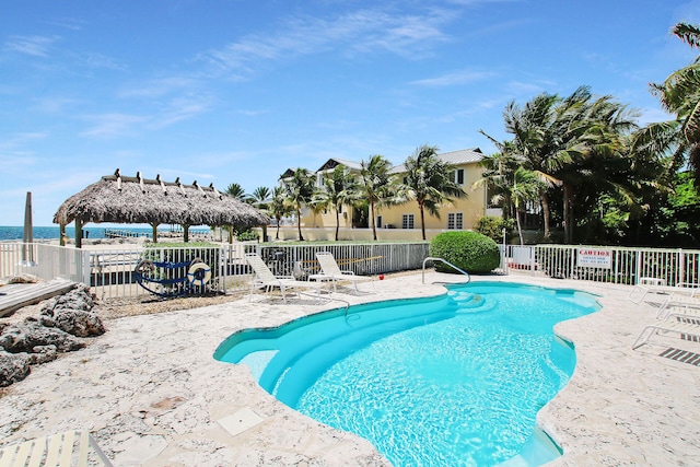 view of pool with a gazebo, a water view, and a patio area