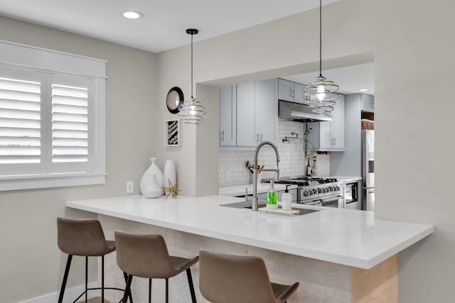 122 S Bay Harbor Dr, Key Largo, FL 33037 - kitchen featuring under cabinet range hood, decorative backsplash, a peninsula, a sink, and a breakfast bar