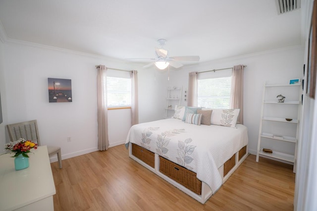 bedroom with crown molding, hardwood / wood-style floors, and multiple windows