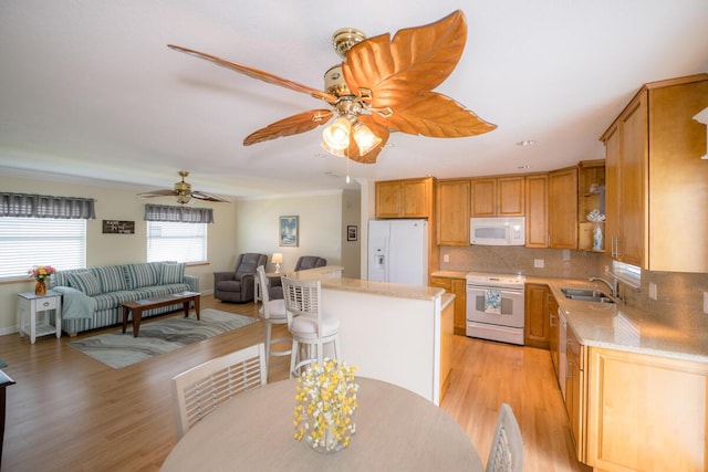 kitchen featuring sink, crown molding, light wood-type flooring, white appliances, and decorative backsplash