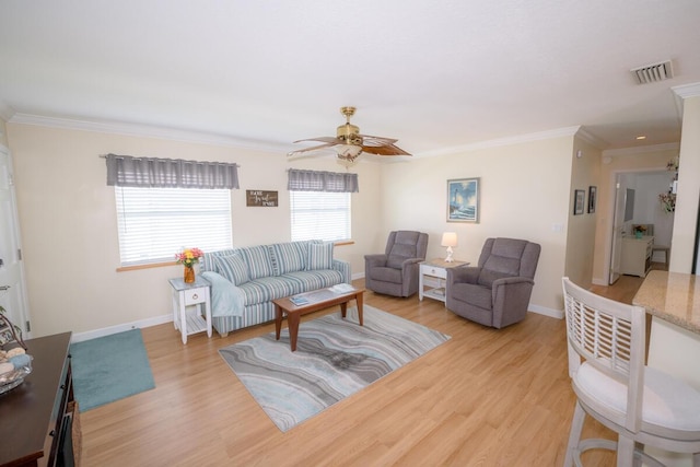 living room with ornamental molding, ceiling fan, and light wood-type flooring