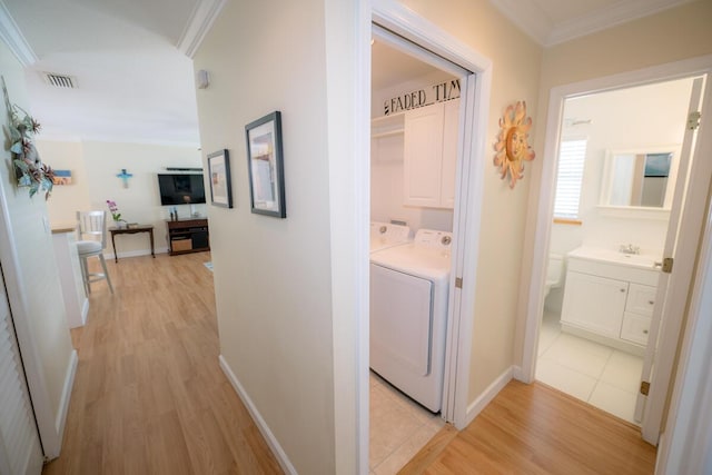 hall with ornamental molding, separate washer and dryer, sink, and light wood-type flooring