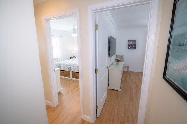 hall featuring crown molding and light wood-type flooring