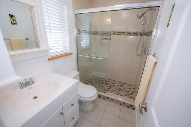 bathroom featuring a shower with door, vanity, tile patterned flooring, and toilet