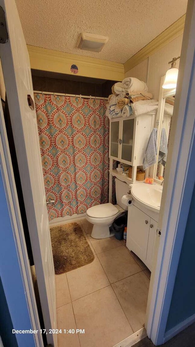 bathroom featuring toilet, crown molding, a textured ceiling, vanity, and tile patterned flooring