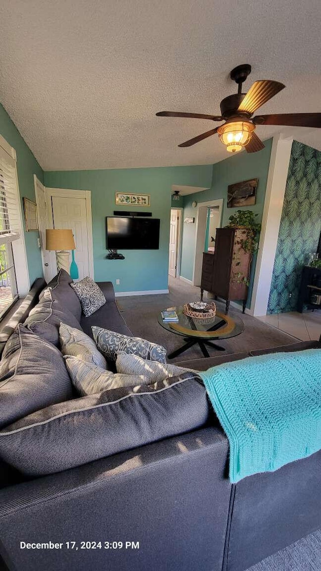 living room with ceiling fan and a textured ceiling