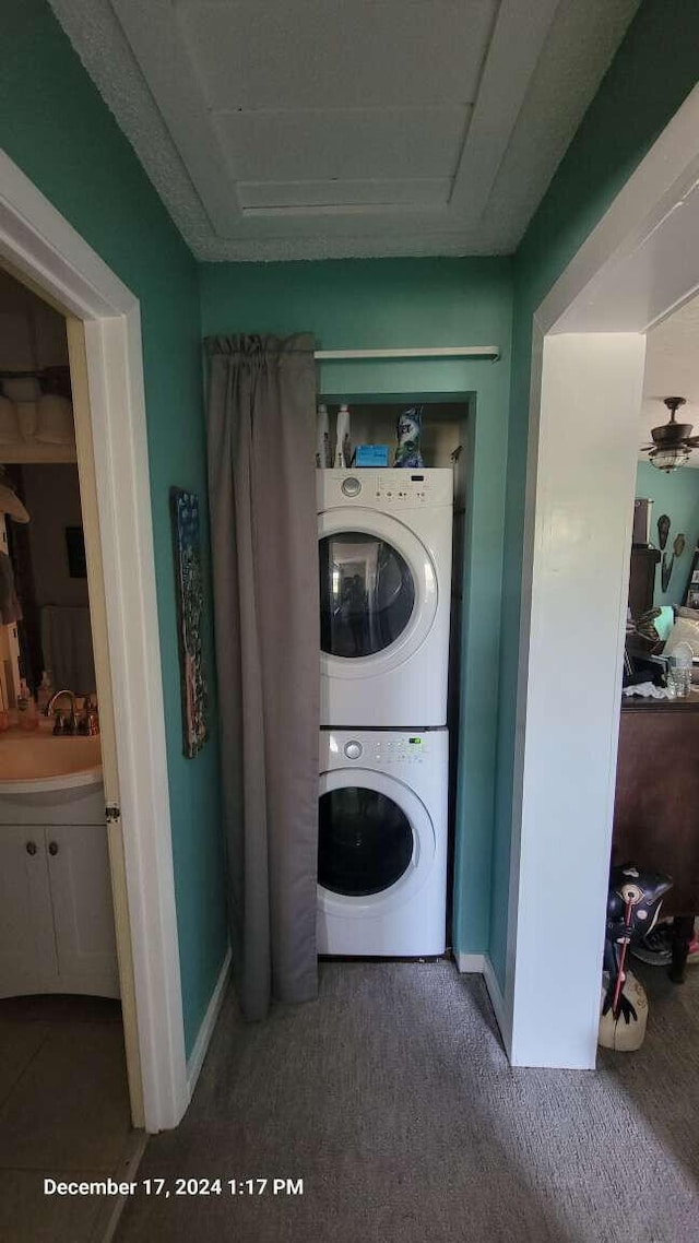 laundry area with stacked washer / dryer and sink