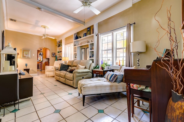 tiled living room featuring crown molding, built in features, and ceiling fan