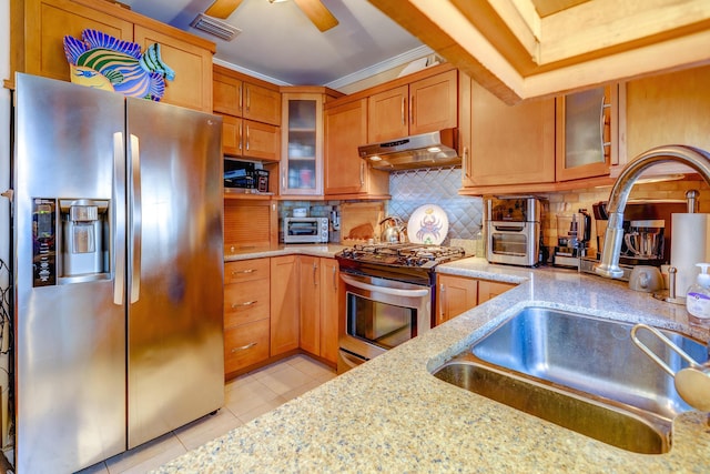 kitchen with light tile patterned flooring, sink, light stone counters, appliances with stainless steel finishes, and backsplash