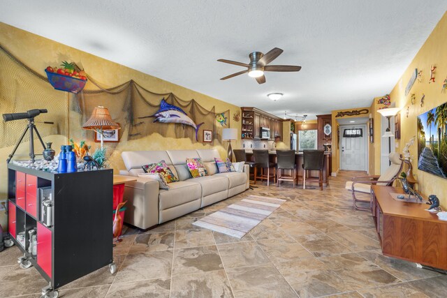 living room with a textured ceiling and ceiling fan