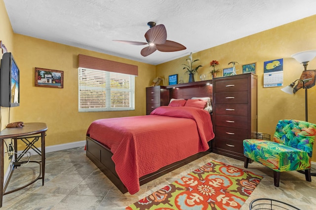 bedroom featuring ceiling fan and a textured ceiling