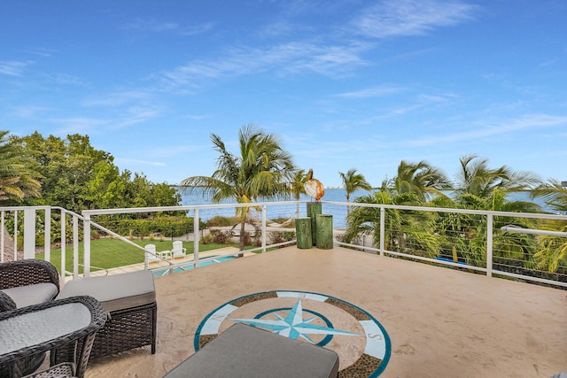 view of patio featuring a water view and a balcony