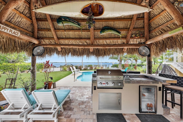 view of patio / terrace featuring exterior kitchen, a gazebo, a grill, and an outdoor wet bar