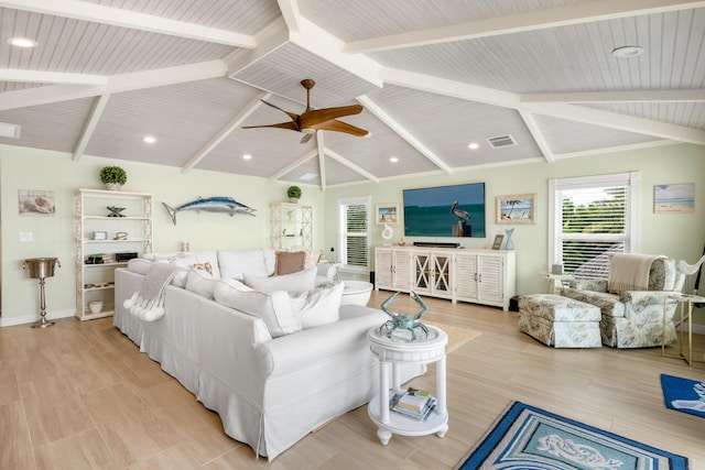 living room with ceiling fan, light hardwood / wood-style floors, and vaulted ceiling with beams