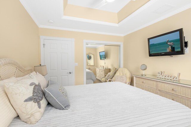 bedroom with crown molding, a raised ceiling, and a closet