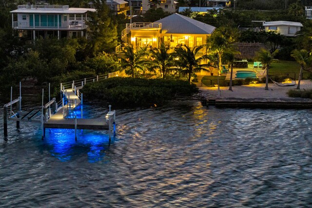 view of swimming pool featuring a water view and a dock