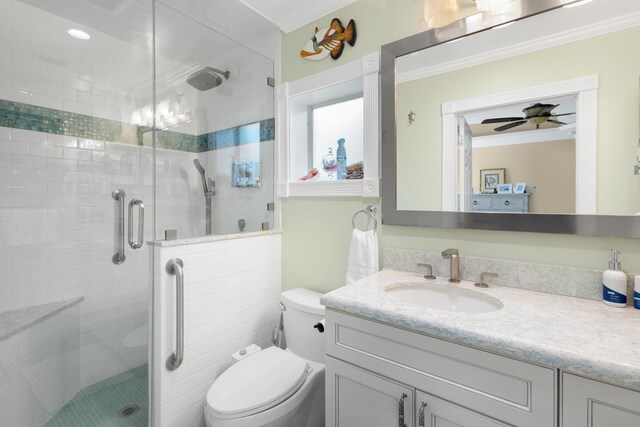 bathroom featuring walk in shower, toilet, ornamental molding, vanity, and ceiling fan